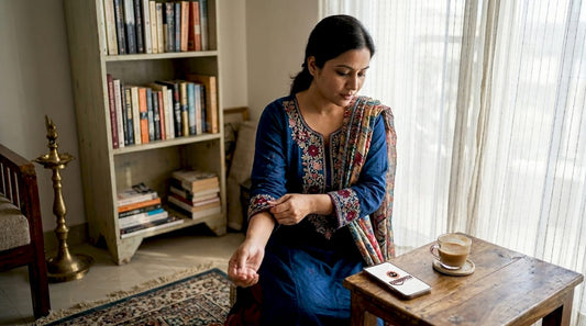 Woman adjusting embroidered shalwar suit at home
