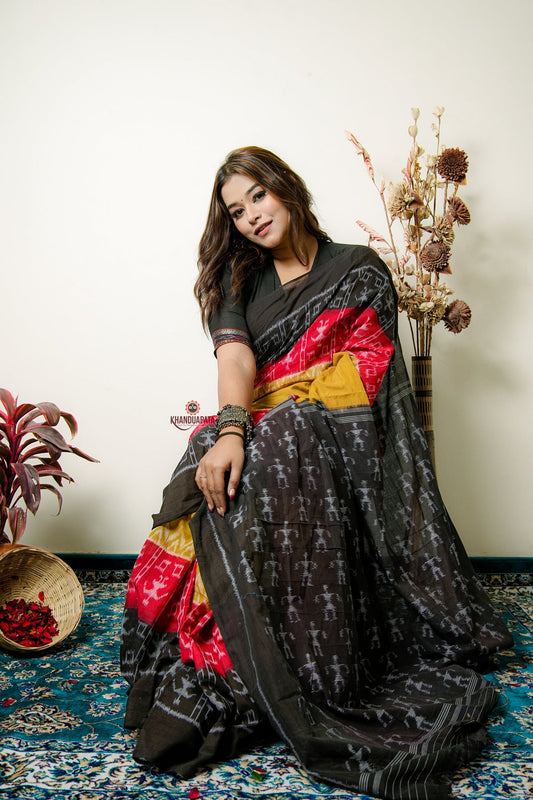 Woman wearing a black and red saree with a floral background