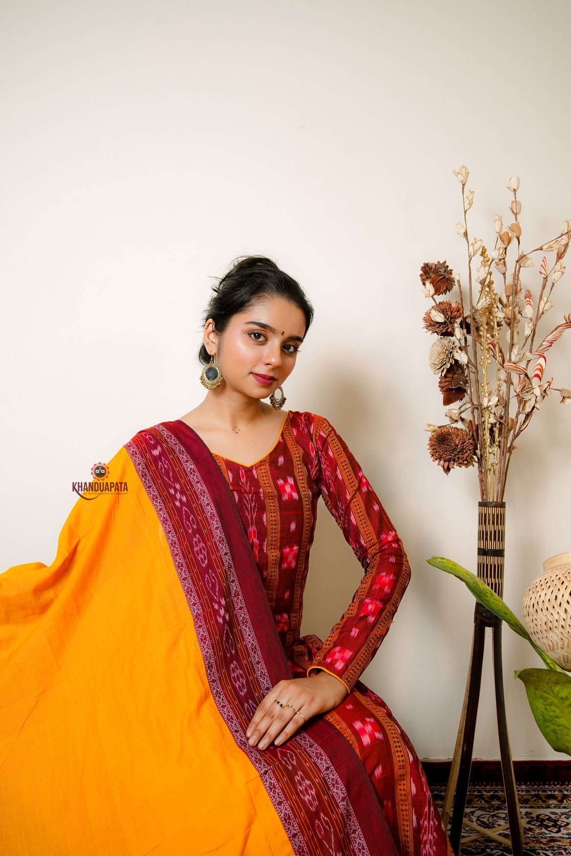 Woman in a traditional outfit with a decorative background