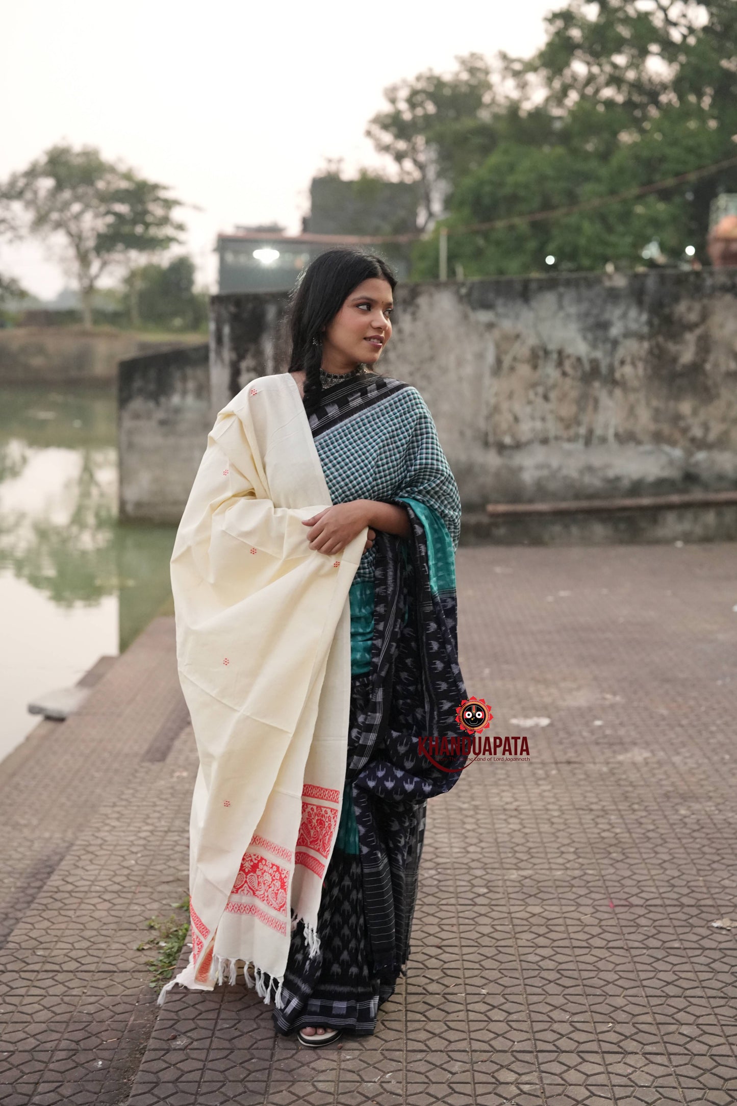 Woman holding a white saree with a scenic background