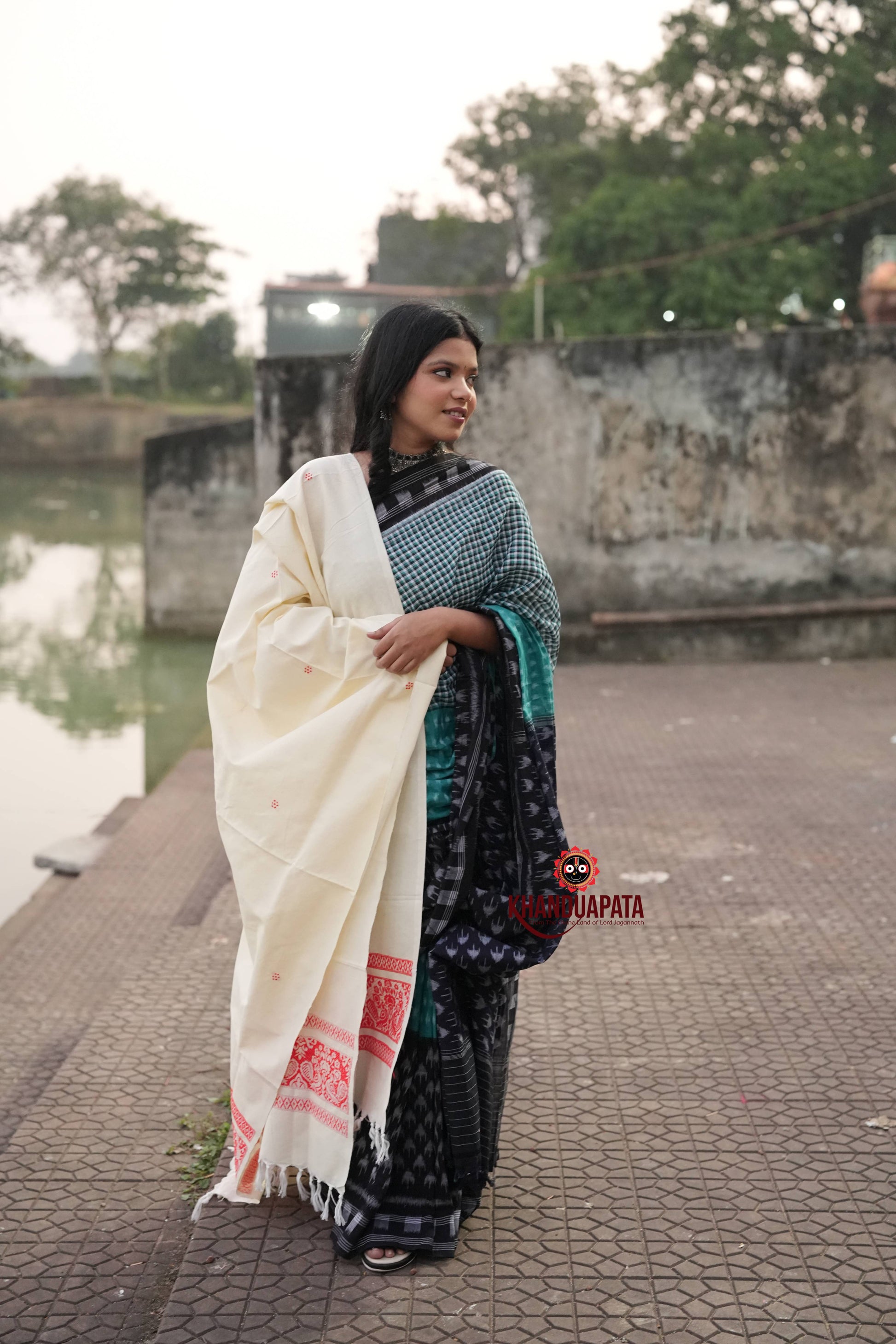 Woman holding a white saree with a scenic background