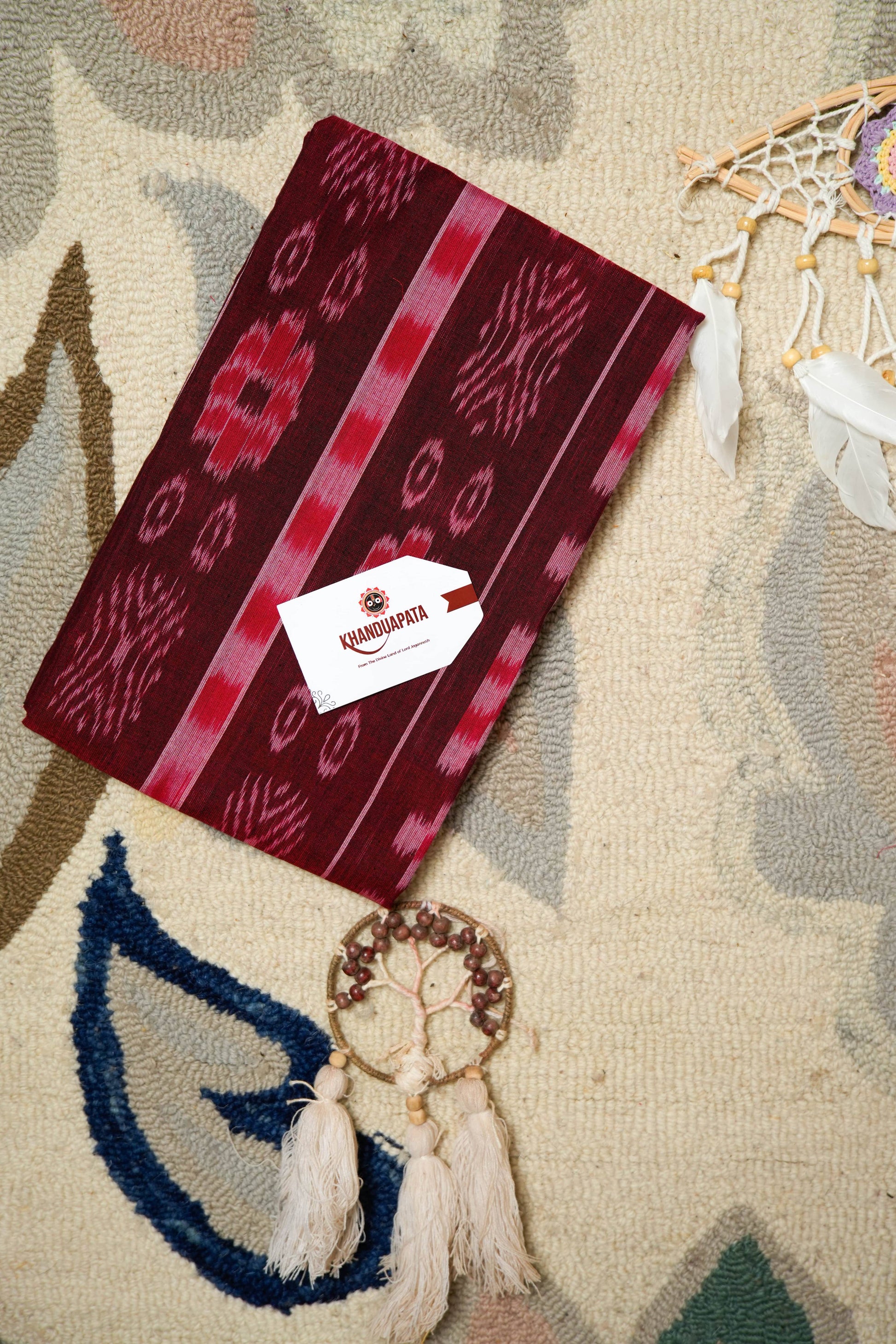 Red patterned pouch with a brand label on a textured surface